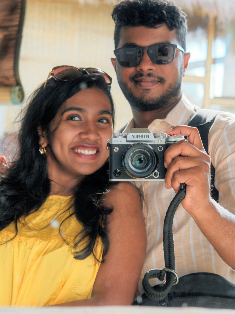 Stive and Shirley in a bamboo hut in Bali, holding a camera to the lens
